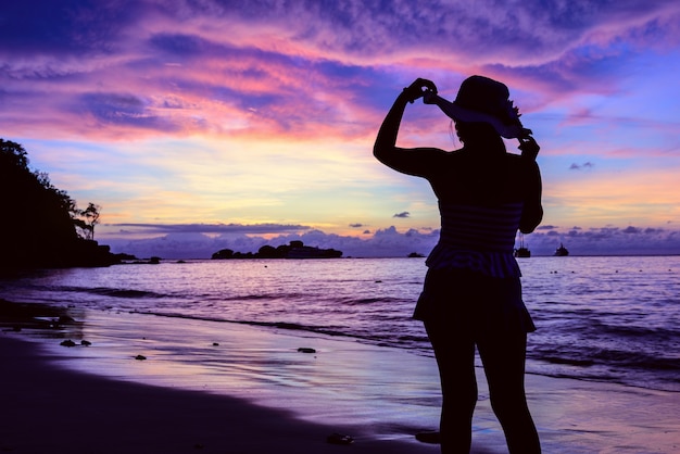 Hermoso paisaje de colorido cielo de verano durante el amanecer y la silueta de una chica en traje de baño posa en la playa en la isla de Miang en el Parque Nacional Mu Koh Similan, provincia de Phang Nga, Tailandia