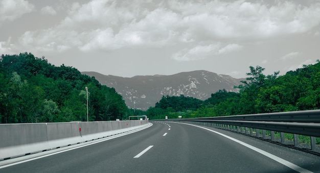 Hermoso paisaje escénico en montañas cubiertas de bosques Vista desde la ventana del auto en una carretera moderna y de alta calidad