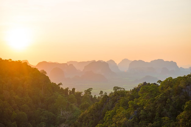 Hermoso paisaje con una espectacular puesta de sol, selva tropical y una empinada cordillera en el horizonte. Krabi, Tailandia