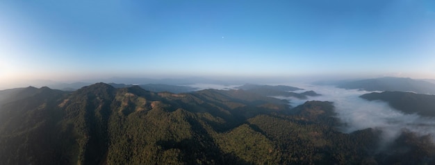 Hermoso paisaje increíble vista aérea Niebla de montaña en el valle por la mañana con fondo de cielo azul