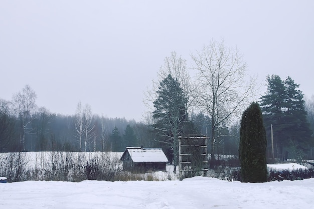 Hermoso paisaje invernal con árboles y antigua casa de baños rural en la nieve en el campo