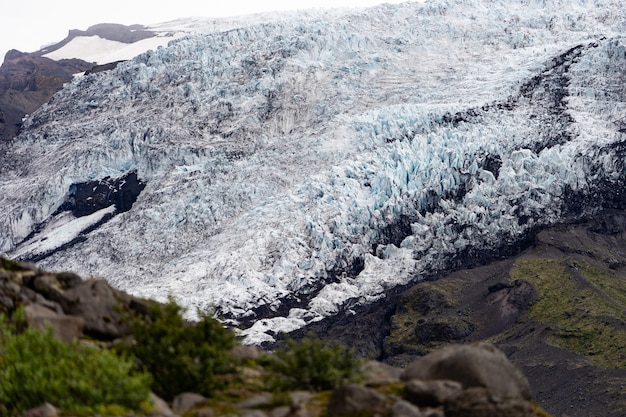 Foto hermoso paisaje islandés con ceniza glaciar y pasto verde