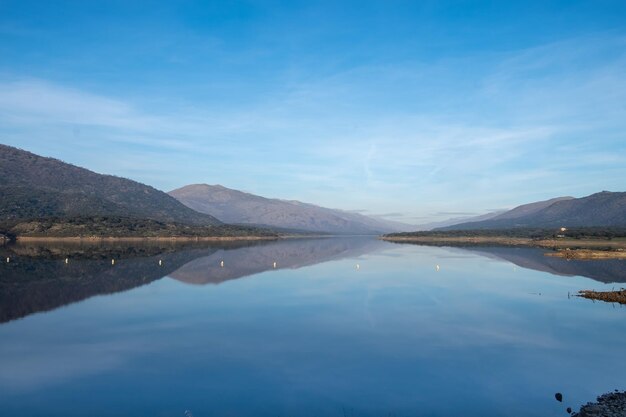 Hermoso paisaje de un lago con un fondo de montañas y nubes