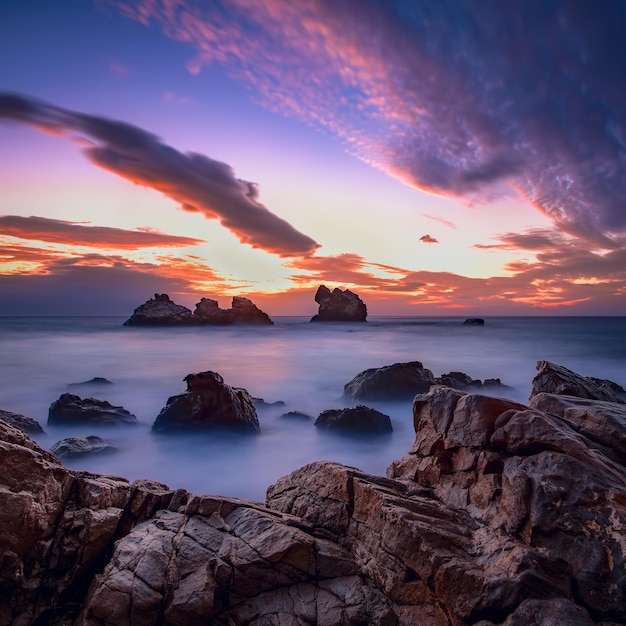 Hermoso paisaje marino al amanecer con nubes en el cielo Hay piedras texturizadas en fragmentos de primer plano