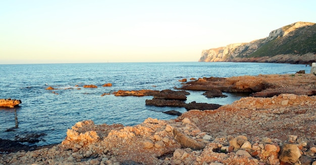 Hermoso paisaje marino, mar, rocas y piedras, cuevas y grutas, iluminación nocturna, puesta de sol, España