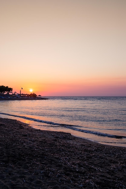 Hermoso paisaje marino con una puesta de sol por la noche cielo púrpura con nubes sobre el océano mar surf con olasMar brillante y dinámico playaNaturaleza medio ambiente cambio climático clima voluble