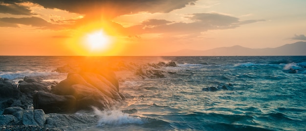 Hermoso paisaje marino con rocas y olas al atardecer