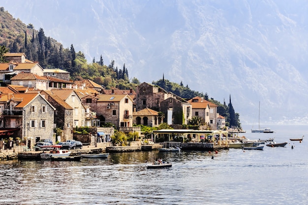 Hermoso paisaje mediterráneo - ciudad medieval en la línea de la playa con el telón de fondo de las montañas, la bahía de Kotor, Montenegro