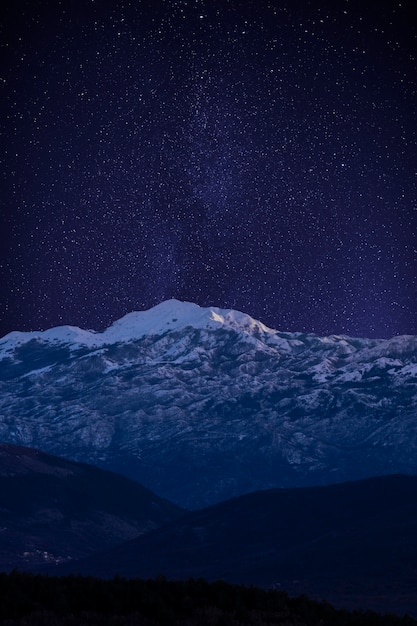 Foto hermoso paisaje con montaña y cielo estrellado.