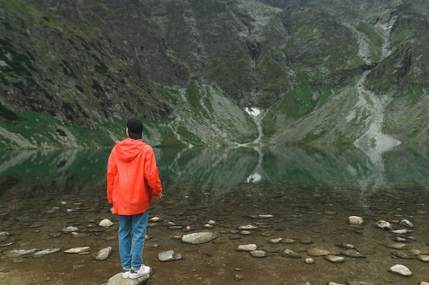 Hermoso paisaje de montaña y lago con hombre