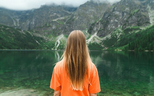 Hermoso paisaje de montaña y lago con mujer