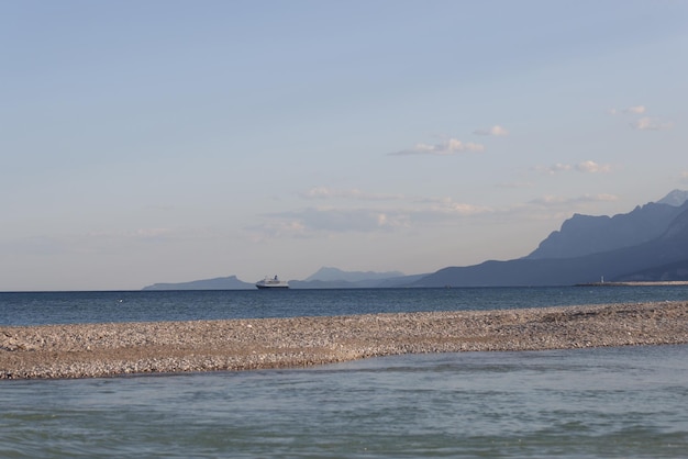 Hermoso paisaje con montañas marinas y cruceros en la línea del horizonte vacaciones de verano en la playa