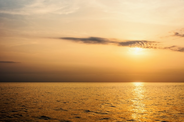 Hermoso paisaje natural de cielo colorido y cálida luz naranja del sol al atardecer sobre el mar durante el verano para el fondo en Tailandia