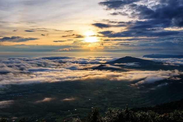 Hermoso paisaje de la naturaleza el sol está sobre la niebla del mar que cubre las montañas y el cielo brillante durante el amanecer en el invierno en el mirador del Parque Nacional Phu Ruea, provincia de Loei, Tailandia.