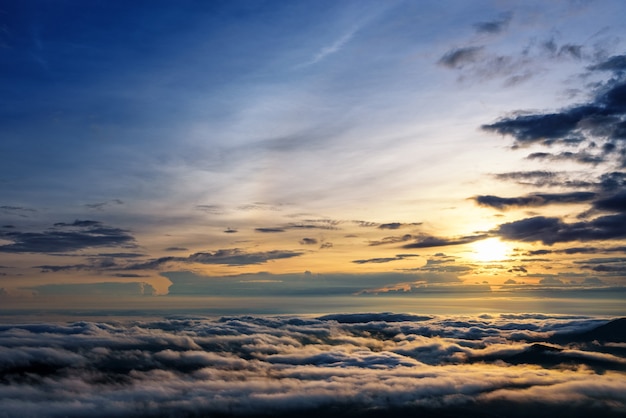 Hermoso paisaje de la naturaleza el sol está sobre la niebla del mar que cubre las montañas y el cielo brillante durante el amanecer en el invierno en el mirador del Parque Nacional Phu Ruea, provincia de Loei, Tailandia.