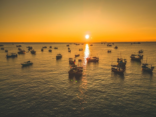 Hermoso paisaje de nubes sobre el amanecer del mar Disparo Barcos solitarios Mar en calma con cielo al atardecer y sol a través de las nubes Mar en calma con cielo al atardecer o amanecer y sol a través de las nubes