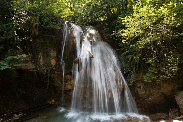 Un hermoso paisaje de una pequeña cascada profunda con agua que fluye en el río de montaña europeo. foto de alta calidad