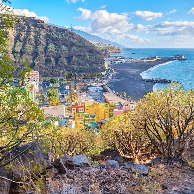 Hermoso paisaje de una pequeña ciudad costera colorida cerca de la playa Ciudad brillante y vibrante cerca del mar y la montaña con un cielo azul nublado Vista panorámica del antiguo y antiguo pueblo urbano