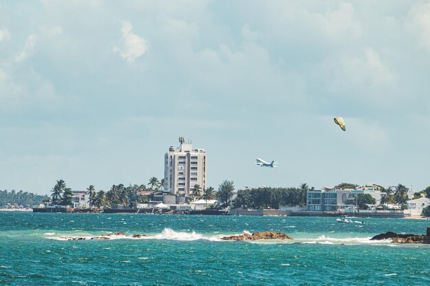 Foto hermoso paisaje de playa de la ciudad de condado con avión volando desde la costa tropical de puerto rico