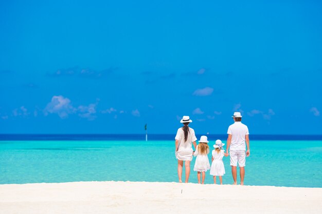 Hermoso paisaje de playa tropical con familia en blanco disfrutando de las vacaciones de verano