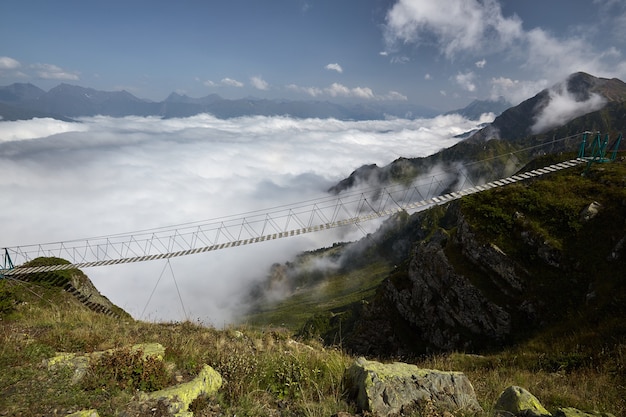 Hermoso paisaje con puente colgante en montaña.