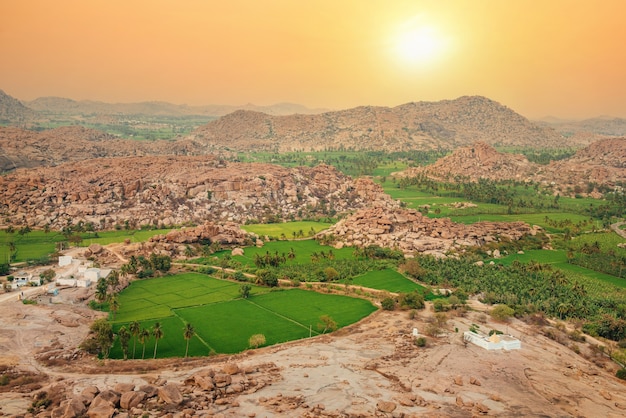 Hermoso paisaje rocoso de montaña de campos de arroz y colinas alrededor de Hampi al atardecer, Karnataka, India