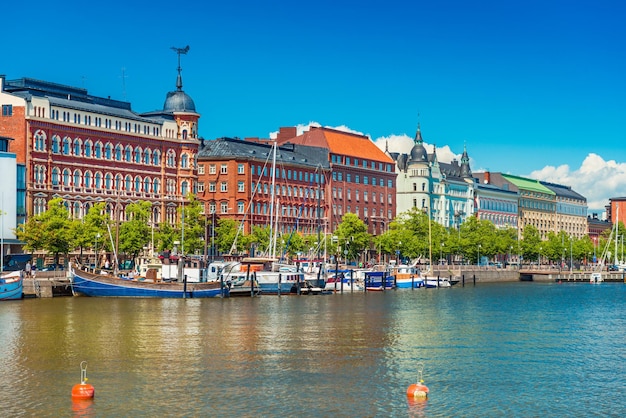 Hermoso paisaje urbano de Helsinki con la arquitectura tradicional, muelle con barcos y cielo azul claro en el fondo, Finlandia