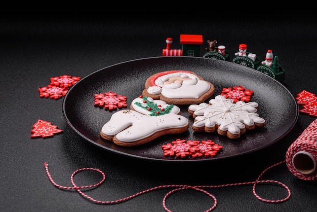 Hermoso pan de jengibre navideño hecho a mano con elementos decorativos sobre un fondo de hormigón oscuro