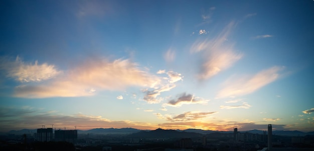 Hermoso panorama natural puesta de sol amanecer sobre siluetas horizonte de la ciudad y asombroso cielo azul nube amarilla sobre él