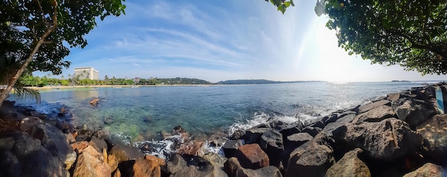 Foto hermoso panorama de playa soleada playa exótica del océano con fondo tropical de rocas