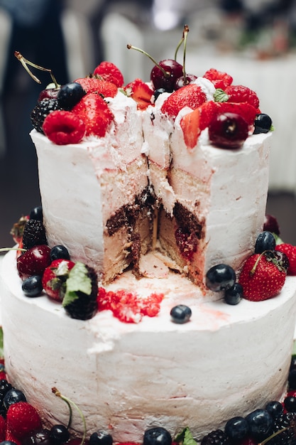 Hermoso pastel de bodas con bayas. Pastel de bodas en rodajas en primer plano.