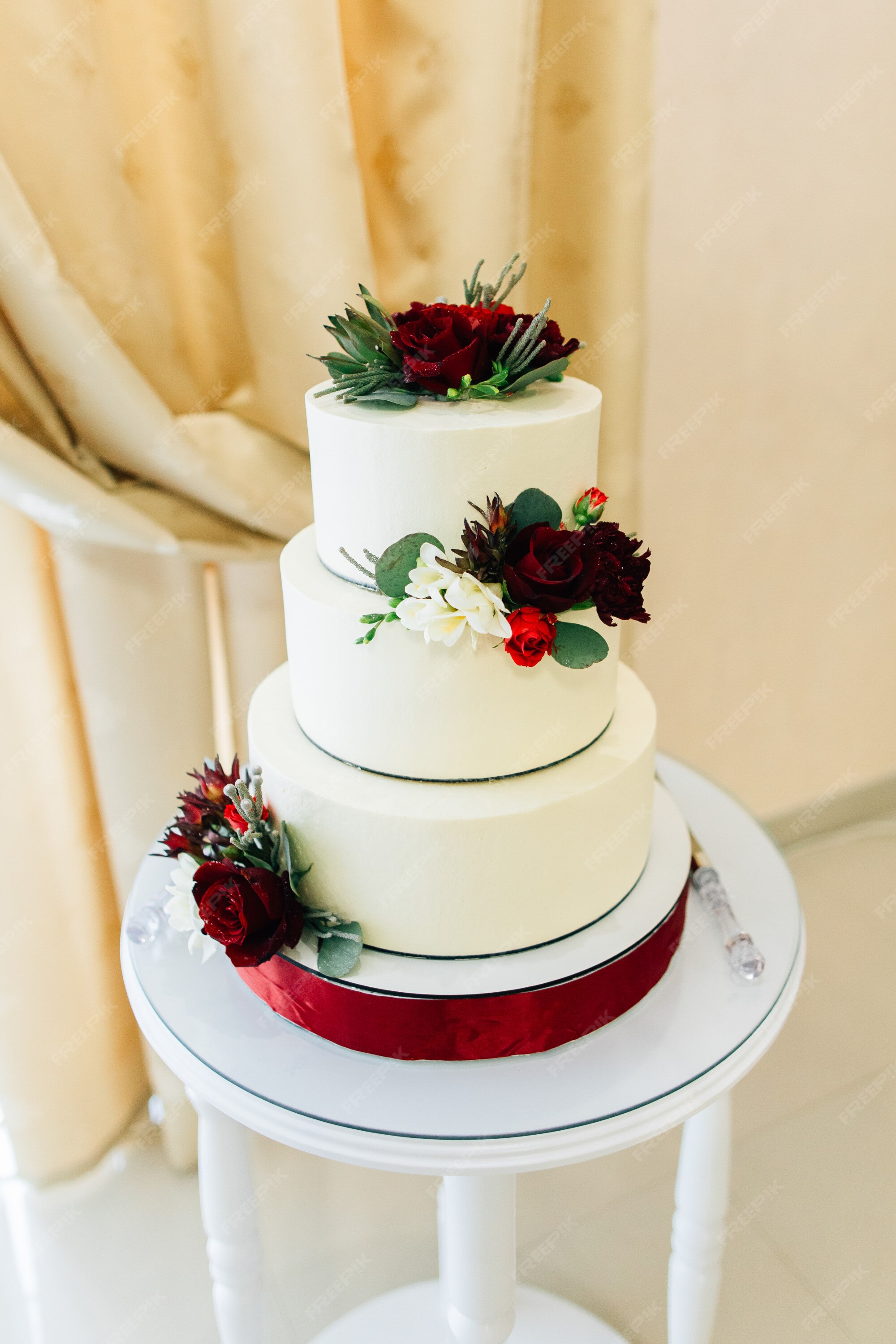 Hermoso pastel de bodas decorado con rosas rojas | Foto Premium