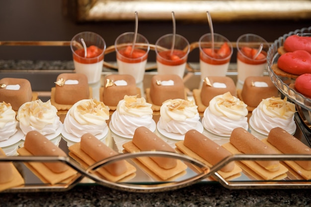 Un hermoso pastel de bodas de pie entre la barra de dulces Mesa dulce Mesa de banquete Comida festiva