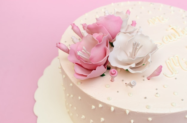 Hermoso pastel decorado con rosas en la mesa de madera casera