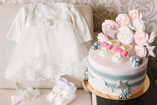 Un hermoso pastel hecho de ingredientes naturales con zapatos para niños en colores rosa y gris para el cumpleaños o bautizo de una niña
