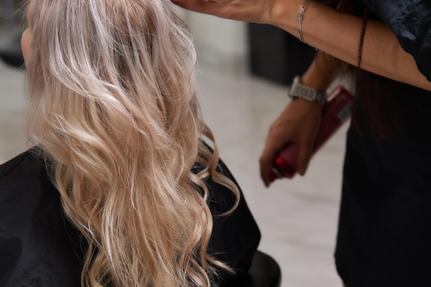 Hermoso peinado de mujer joven después de teñir el cabello y hacer reflejos en la peluquería