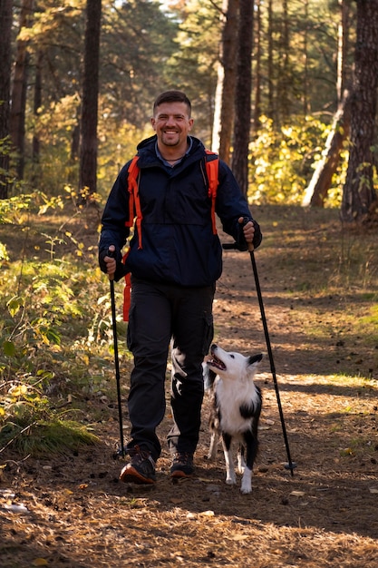 Hermoso perro blanco y negro y hombre senderismo