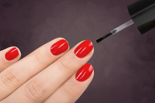 Hermoso proceso de manicura. Esmalte de uñas aplicado a mano, el esmalte es de color rojo.