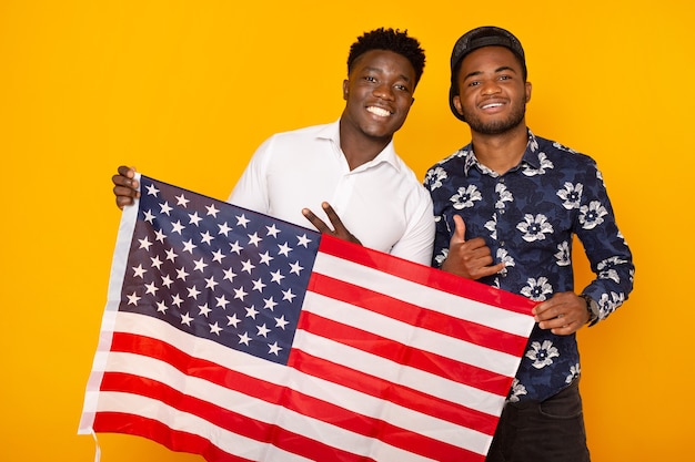 Hermoso pueblo africano con bandera americana sobre fondo amarillo