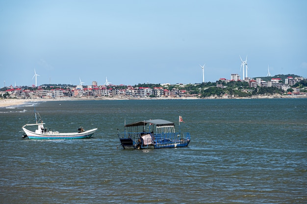 Hermoso pueblo de pescadores, cielo azul y nubes blancas, mar y pequeñas embarcaciones