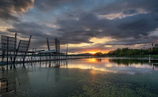 Hermoso puente largo sobre el lago en la ciudad al atardecer