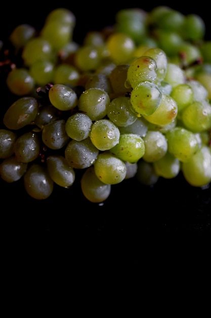 Hermoso racimo de uvas frescas sobre un fondo de madera oscura Las gotas de agua Alimentación saludable