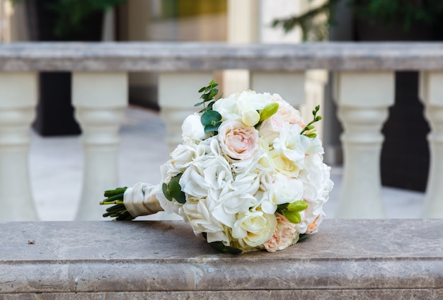 Hermoso ramo de boda de eustoma y rosas en barandilla de mármol vintage