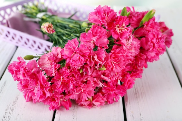 Hermoso ramo de clavel rosa en la mesa de madera de cerca