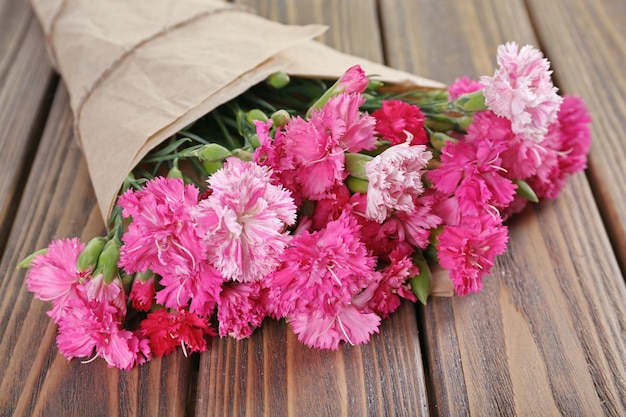 Hermoso ramo de clavel rosa en la mesa de madera de cerca