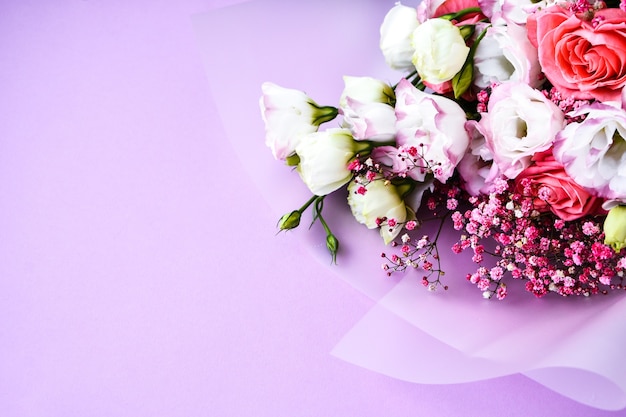 Hermoso ramo de diferentes flores sobre fondo morado. Copie el espacio para el texto. Tarjeta de felicitación navideña. cubrir