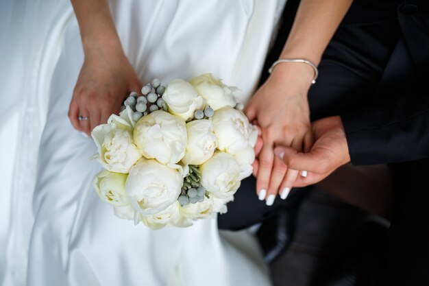 Hermoso ramo de flores de boda en manos de los recién casados.