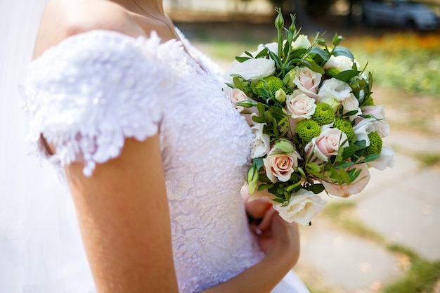 Foto hermoso ramo de flores de boda en manos de los recién casados.