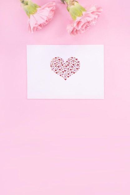 Hermoso ramo de flores de clavel elegante y fresco con saludo blanco gracias tarjeta de regalo aislado sobre fondo de color rosa brillante vista superior concepto laico plano