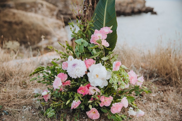 Un hermoso ramo de flores se encuentra sobre la hierba seca